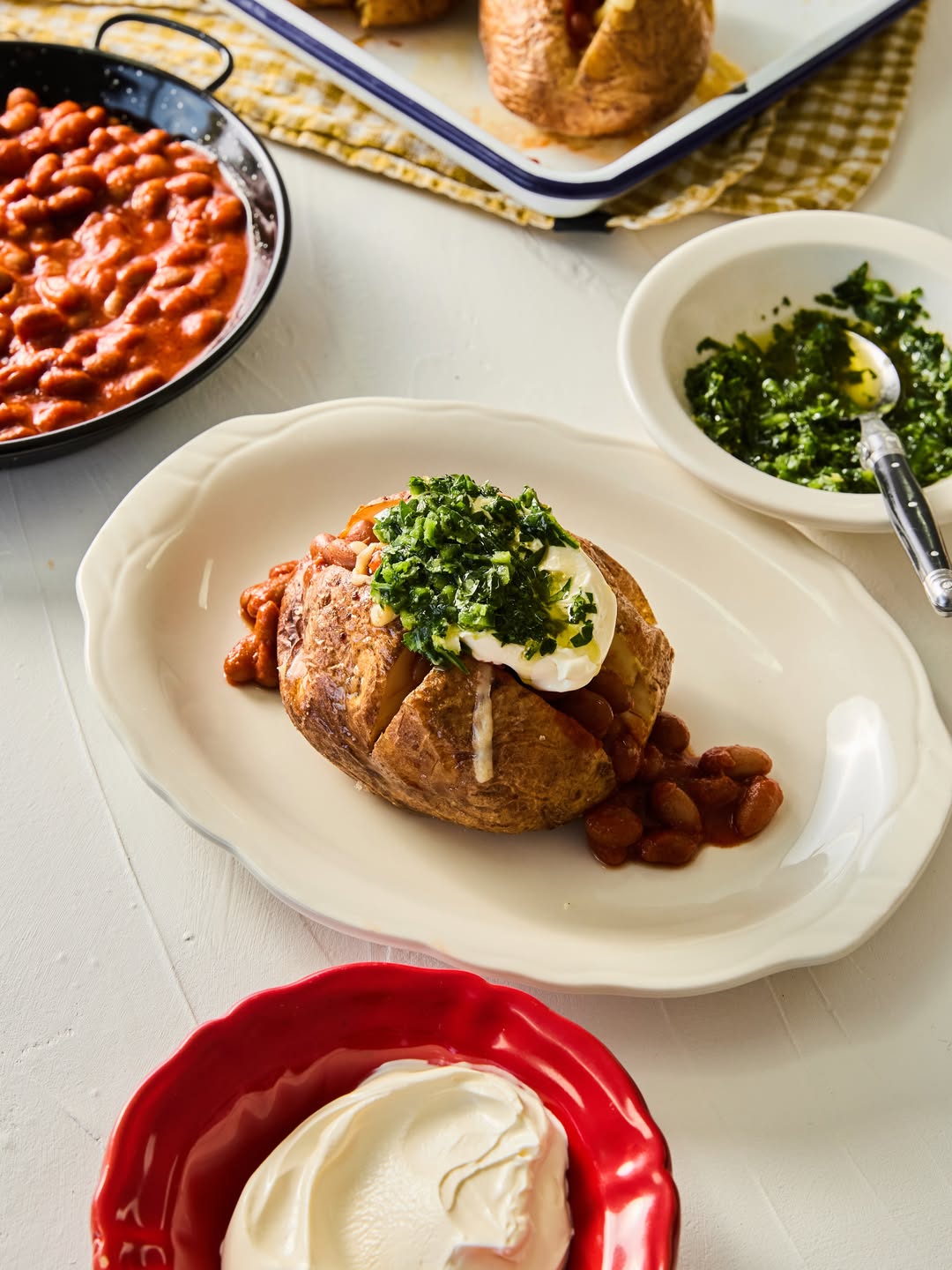 Baked beans on a baked jacket potato with grilled cheese and a jalapeño salsa